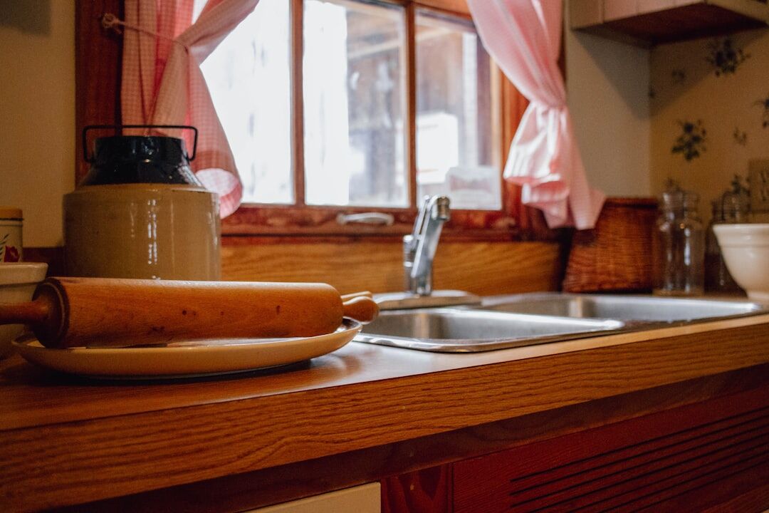 Wooden kitchen utensils and rolling pin on a counter